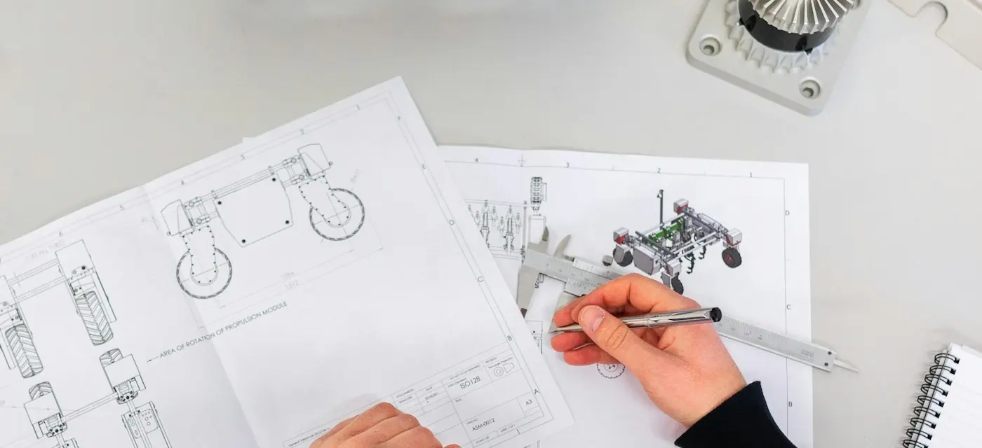 Hands reviewing a technical drawing with calipers